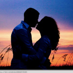 man and woman silhouette sunset kissing