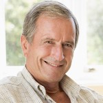 Man in living room with laptop smiling